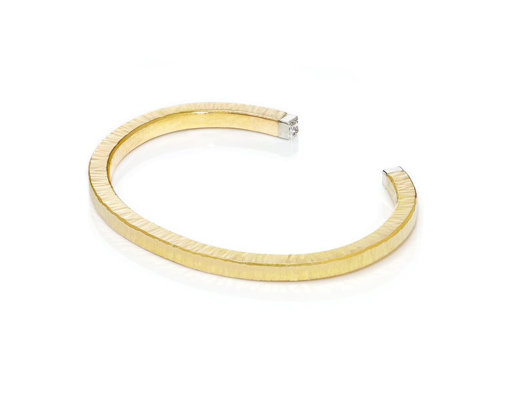 Gold cuff bracelet, textured surface, made of one ounce of gold with square diamonds on the ends